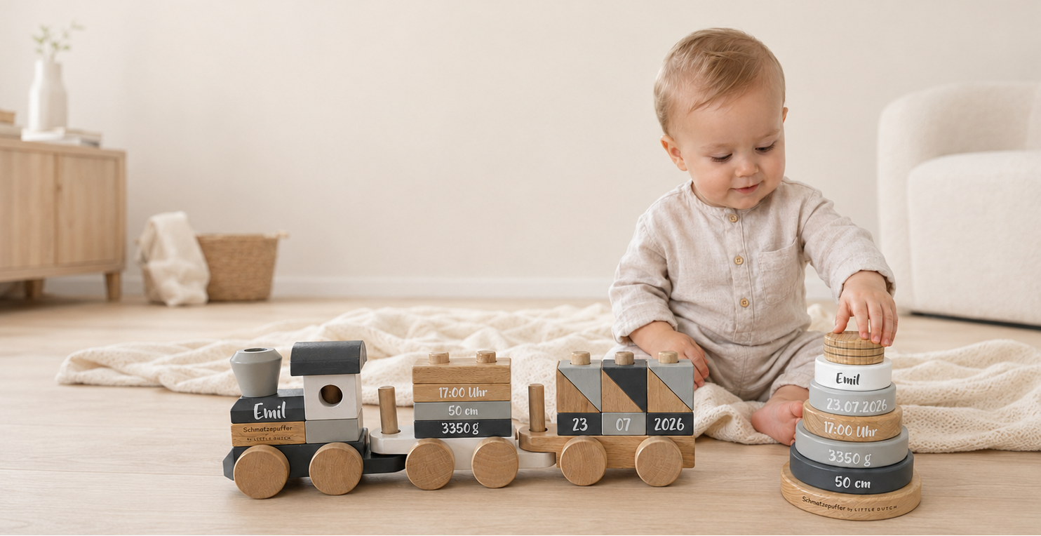 Baby mit personalisiertem Holzzug und Geburtsdaten als Motiv zu Vornamen-Trends 2026 und 2027