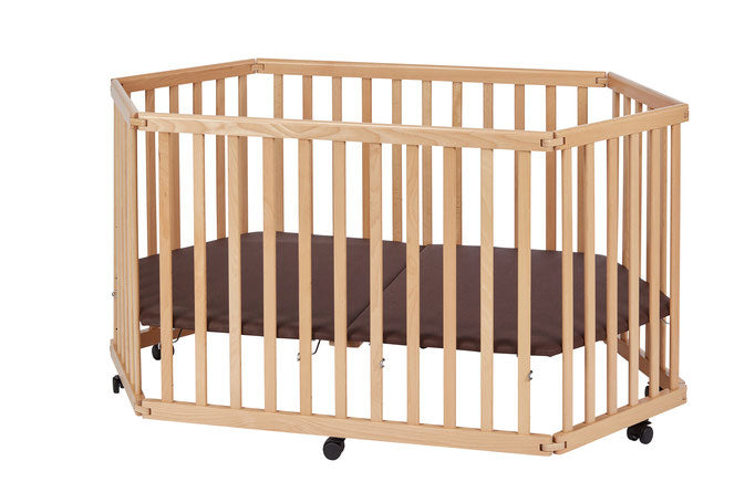 Foldable hexagonal wooden baby playpen in natural beech with brown mattress and wheels with brakes